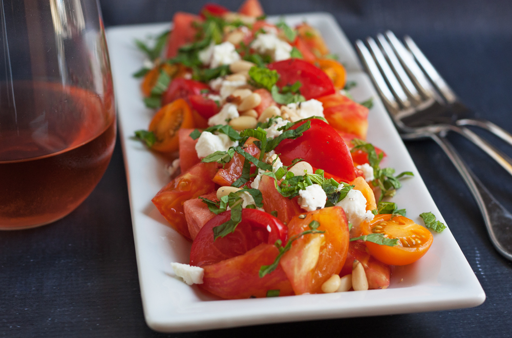 Multi-colored heirloom tomatoes pair beautifully with ripe watermelon, bright herbs, and tangy feta cheese